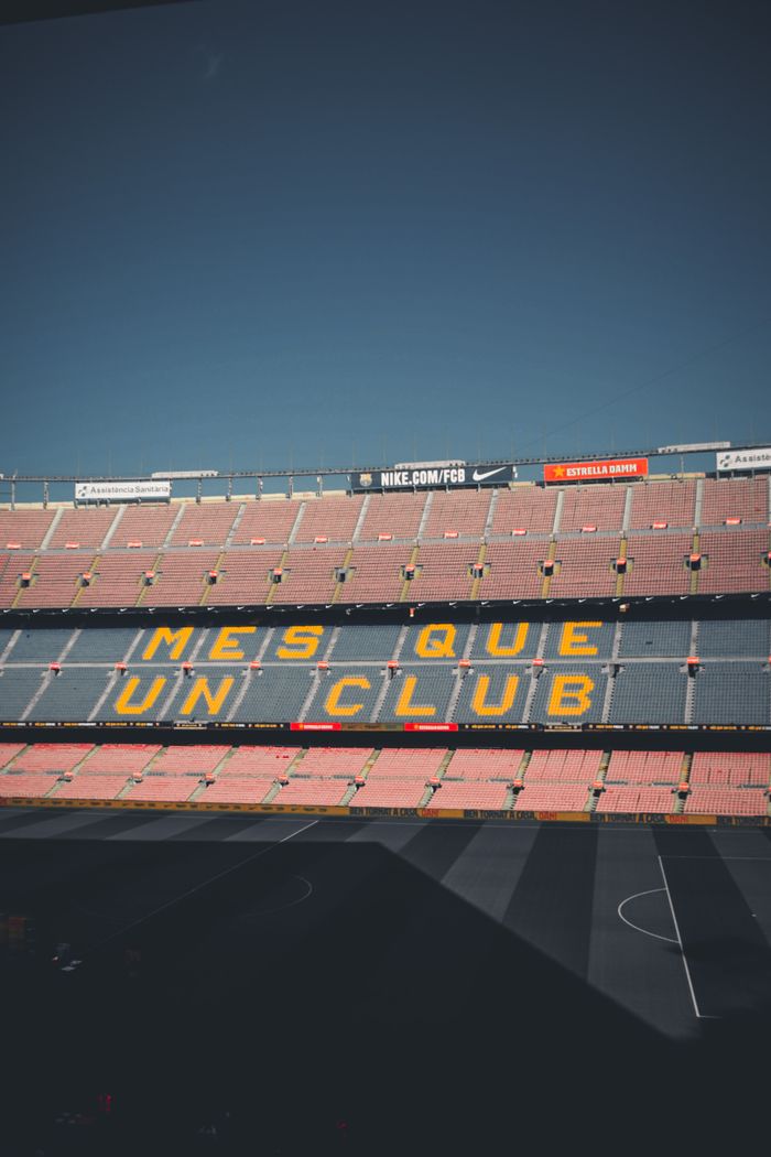 View of Camp Nou's grandstand with the famous motto and a clear blue sky.