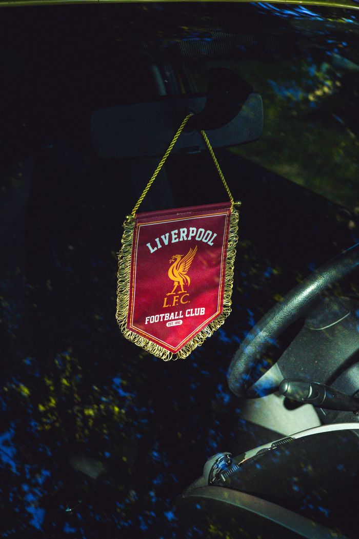 Liverpool FC pennant hanging inside a car, reflecting passion for football.